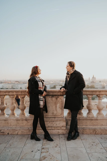 Morning couple photoshoot in Budapest at Buda Castle Couple smiling at each other beside the Buda Castle balustrade during their morning photoshoot in Budapest