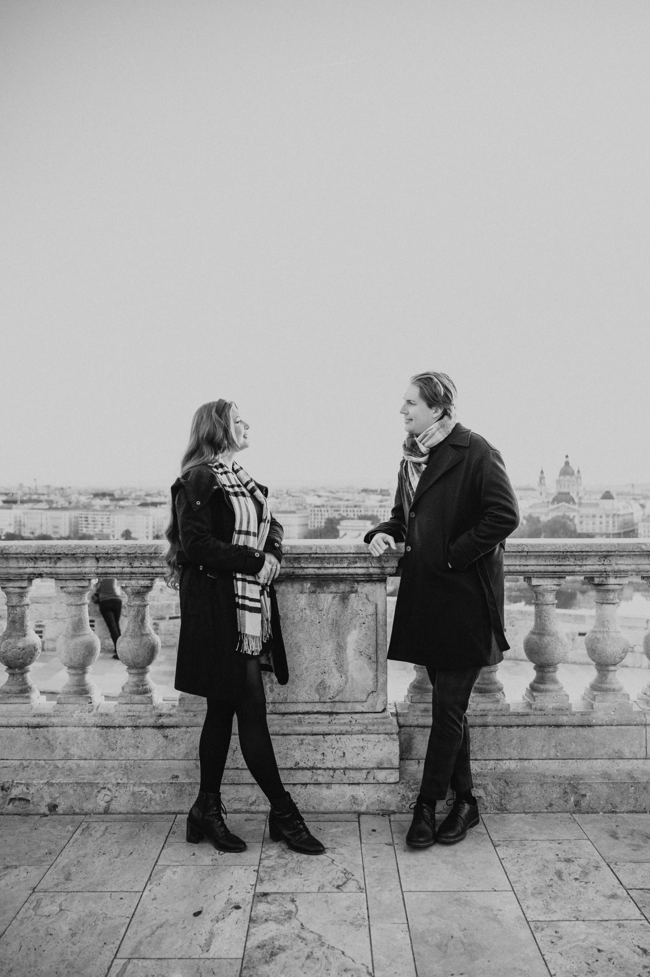 Black and white portrait of a couple holding hands at the Buda Castle balustrade during their Budapest photoshoot