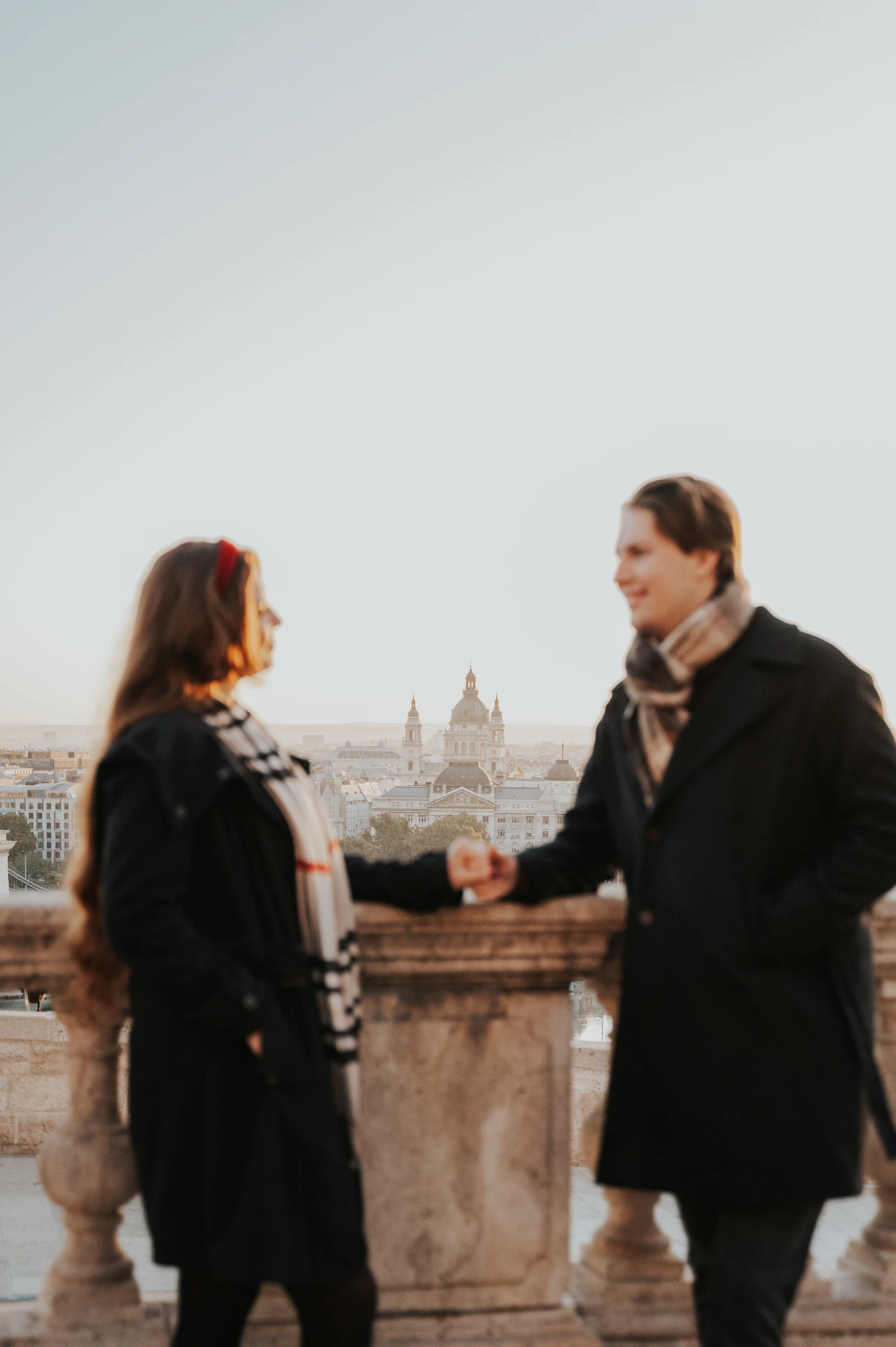 Couple smiling towards each other on a Buda Castle platform during their couple photoshoot in Budapest