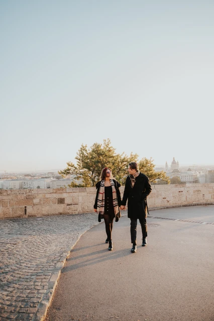 Morning photoshoot in Budapest walking through Buda Castle Couple walking hand in hand through the Buda Castle grounds during their morning photoshoot in Budapest
