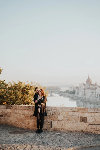 Couple embracing by the stone parapet at Buda Castle during their couple photoshoot in Budapest