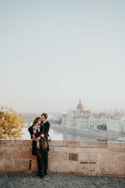 Morning photoshoot in Budapest beside the castle parapet Couple leaning close beside the stone parapet at Buda Castle during their morning photoshoot in Budapest