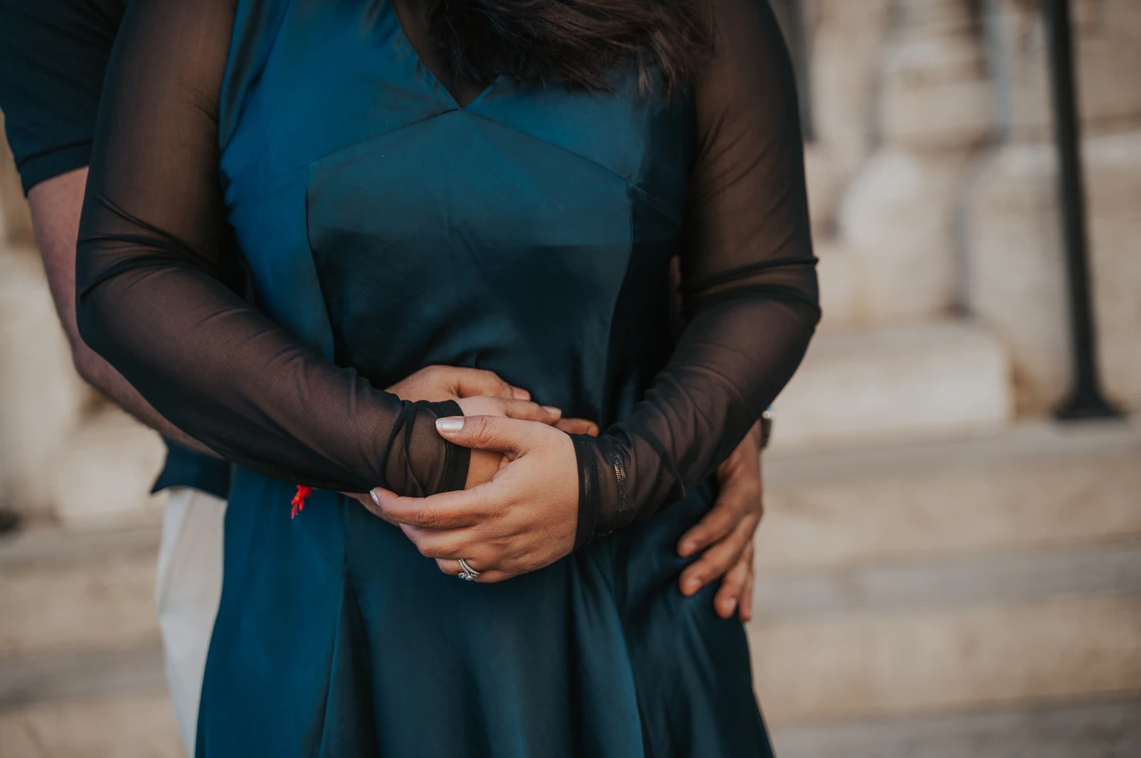 Budapest couple photoshoot: hands together against the teal dress A close detail of the couple’s hands resting together against her teal dress beside Matthias Church during a couple photoshoot in Budapest.