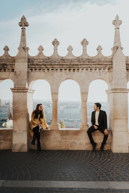 Morning couple photoshoot in Budapest beneath the Fisherman's Bastion arches Married couple standing apart beneath the stone arches at Fisherman's Bastion during their morning photoshoot in Budapest