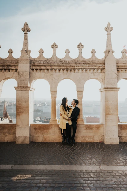 Couple embracing beneath the stone arches at Fisherman's Bastion during their couple photoshoot in Budapest