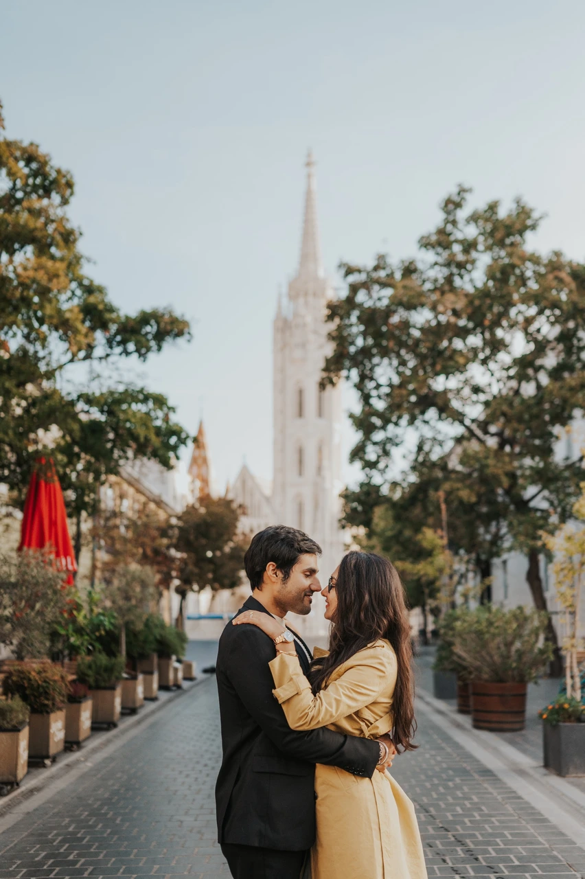 Couple photoshoot in Budapest with an embrace on a cobbled street Couple embracing and leaning close on a cobbled street near Fisherman's Bastion during their Budapest photoshoot