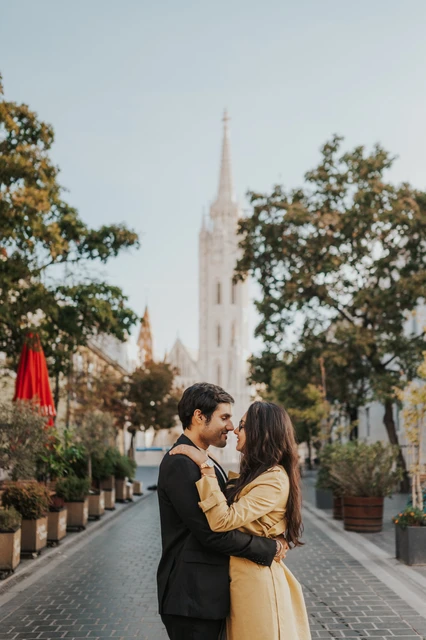 Couple embracing and leaning close on a cobbled street near Fisherman's Bastion during their Budapest photoshoot