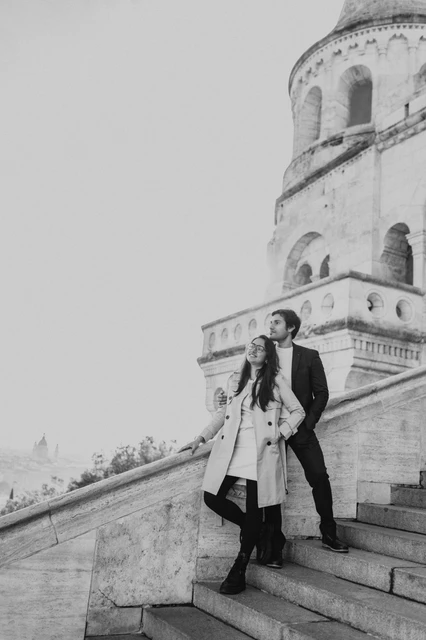 Black and white couple photoshoot in Budapest on the Fisherman's Bastion staircase Black and white portrait of a couple embracing on the stone steps beside a Fisherman's Bastion tower during their Budapest photoshoot