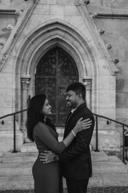Budapest couple photoshoot embrace in black and white Black-and-white portrait of the couple embracing beneath the pointed church doorway during their Budapest couple photoshoot.