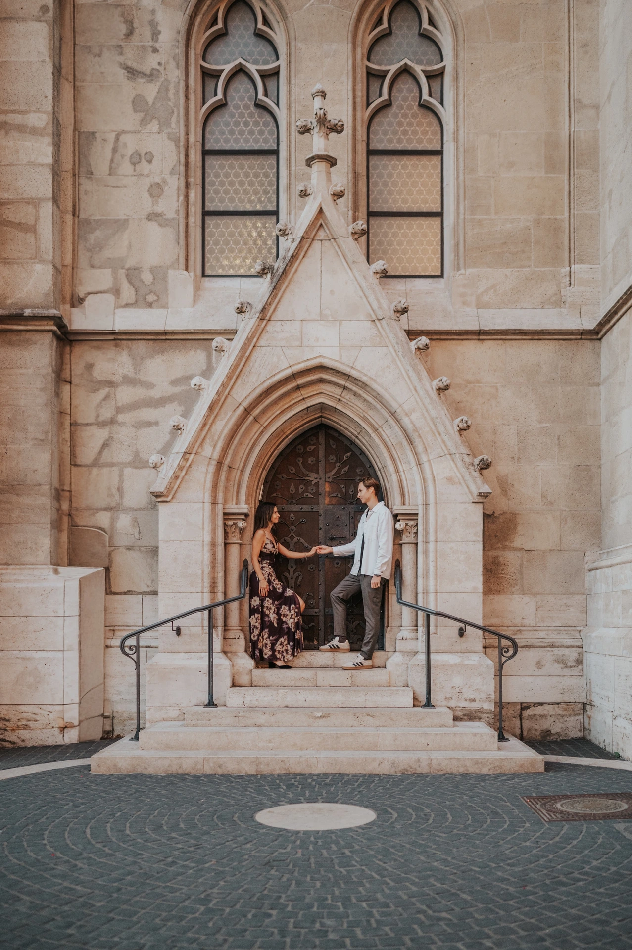 The couple standing together in the ornate church entrance during their Budapest photoshoot near Fisherman’s Bastion.