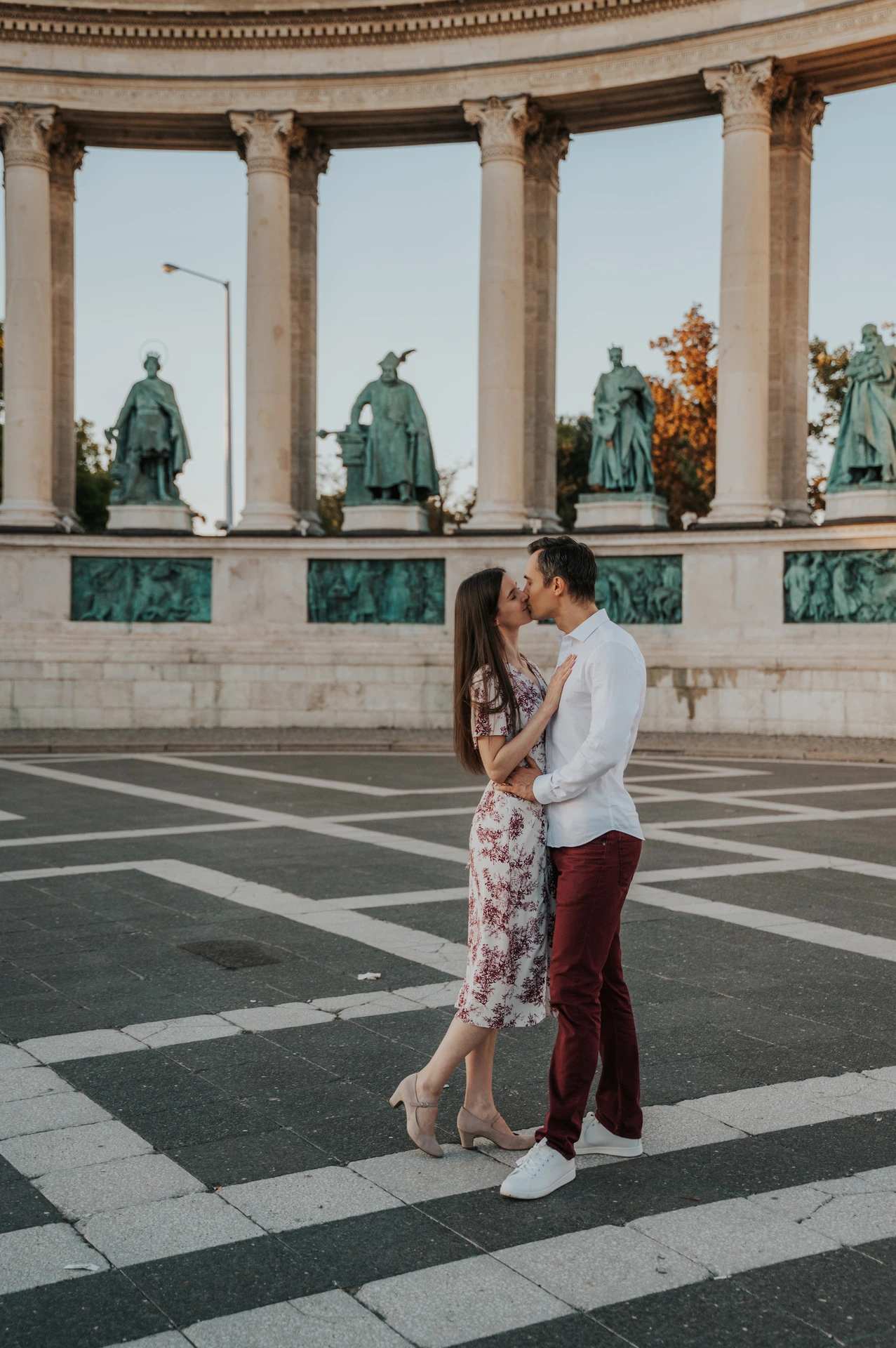 The couple sharing a kiss in front of the colonnade at Heroes’ Square during their couple photoshoot in Budapest.