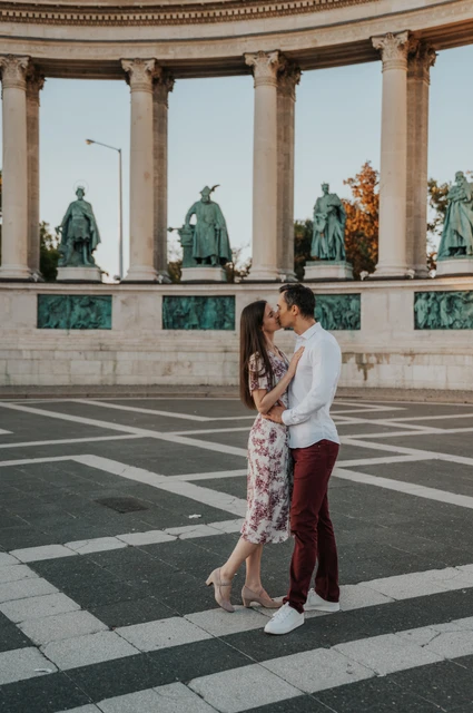 A kiss in front of the colonnade at a Budapest couple photoshoot The couple sharing a kiss in front of the colonnade at Heroes’ Square during their couple photoshoot in Budapest.