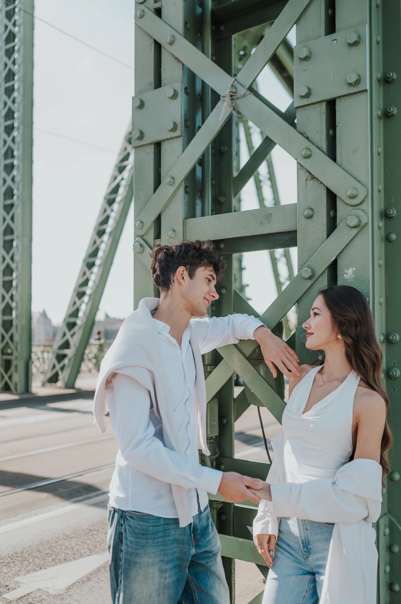 A closer view of the couple sharing a playful look beside the green bridge structure during their Budapest photoshoot on Liberty Bridge.