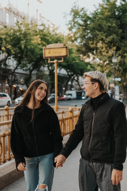 Couple photoshoot in Budapest beside the yellow metro railings A closer portrait of the couple looking towards each other beside the yellow metro railings during their Budapest photoshoot.