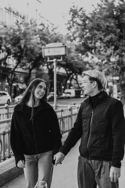 Budapest photoshoot near the metro entrance in black and white Black-and-white portrait of the couple holding hands near a metro entrance during their Budapest photoshoot.