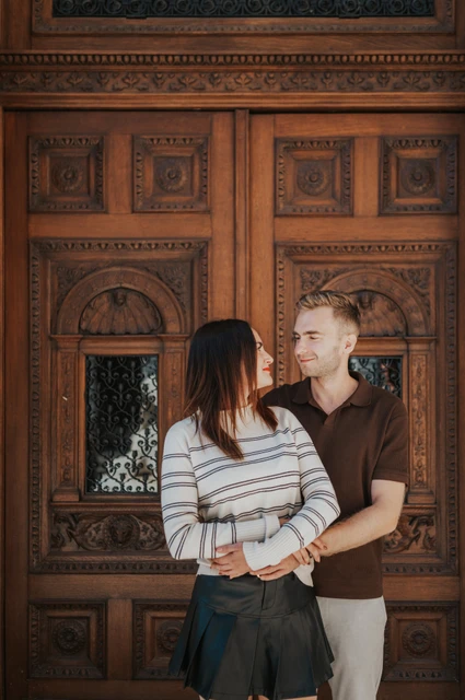Budapest couple photoshoot: a close portrait at the Opera doors A close portrait of the couple in front of the Opera’s ornate wooden doors during a couple photoshoot in Budapest.