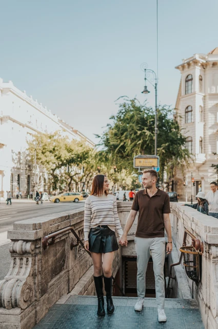 Budapest couple photoshoot: walking up the Opera metro steps The couple walking up the stone steps at Opera metro station during a couple photoshoot in Budapest.
