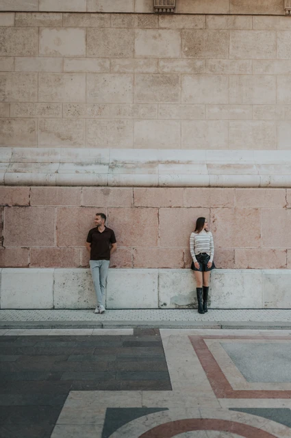 Budapest couple photoshoot: the Basilica’s pale stone wall The couple standing apart against St Stephen’s Basilica’s tall pale stone wall during a couple photoshoot in Budapest.