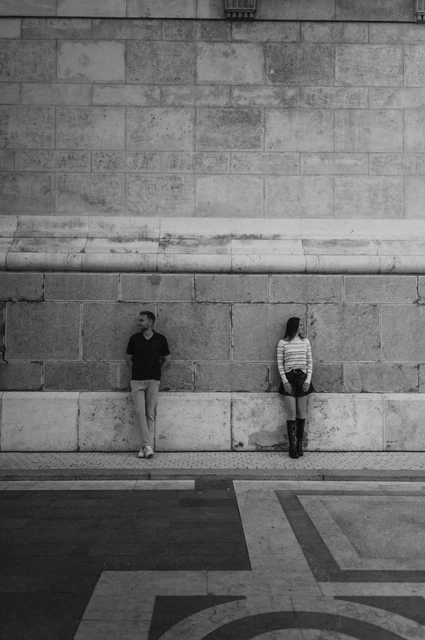 Budapest couple photoshoot: a graphic portrait beside the Basilica wall in black and white Black-and-white photograph of the couple standing on either side of a tall stone wall detail at St Stephen’s Basilica during a couple photoshoot in Budapest.