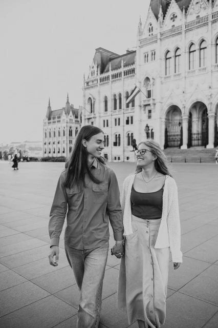 Budapest photoshoot outside Parliament in black and white Black-and-white photograph of the couple walking together during their Budapest photoshoot in front of the Hungarian Parliament.