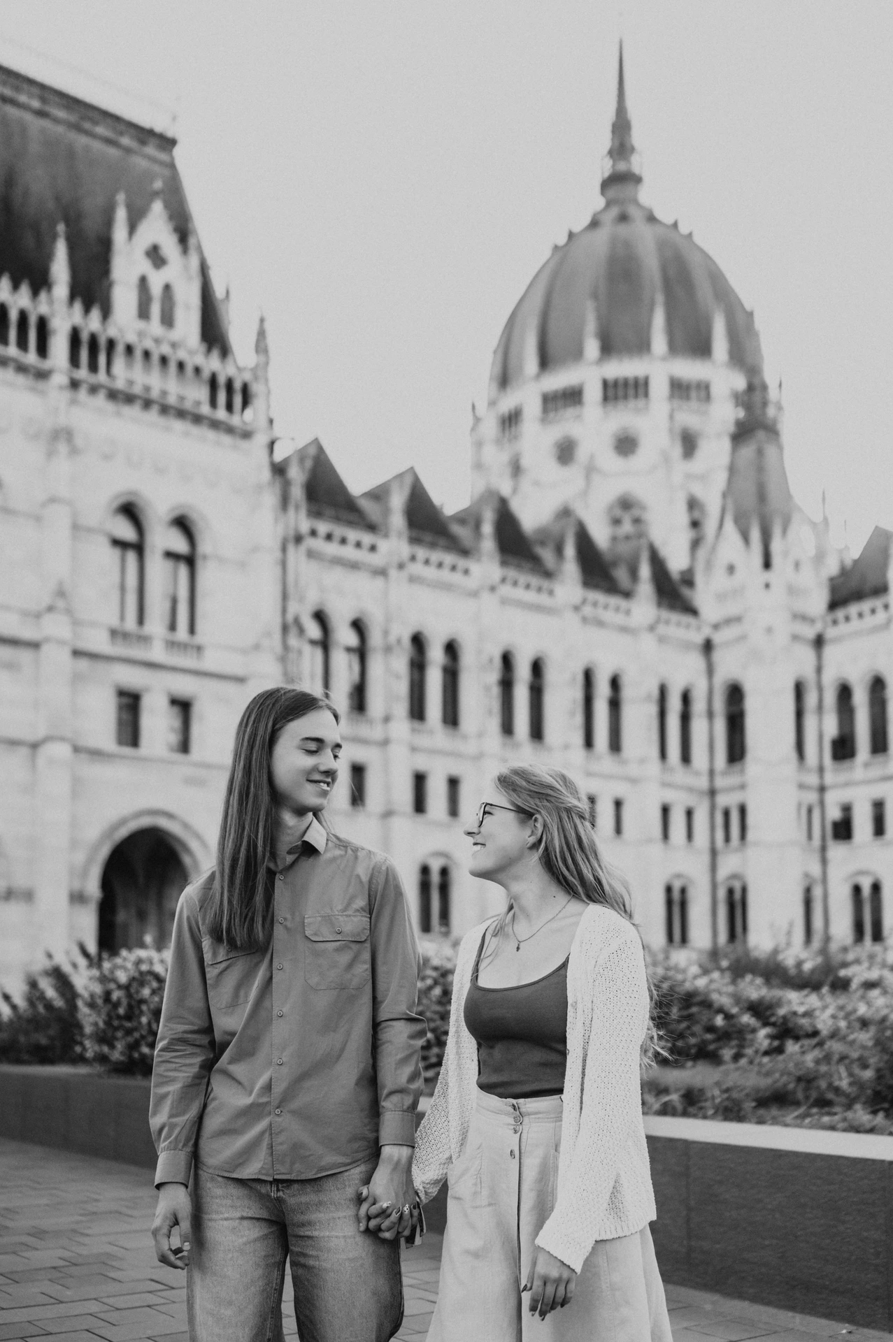 Black-and-white portrait of the couple looking at each other during their Budapest photoshoot, with the dome of Parliament in the backdrop.