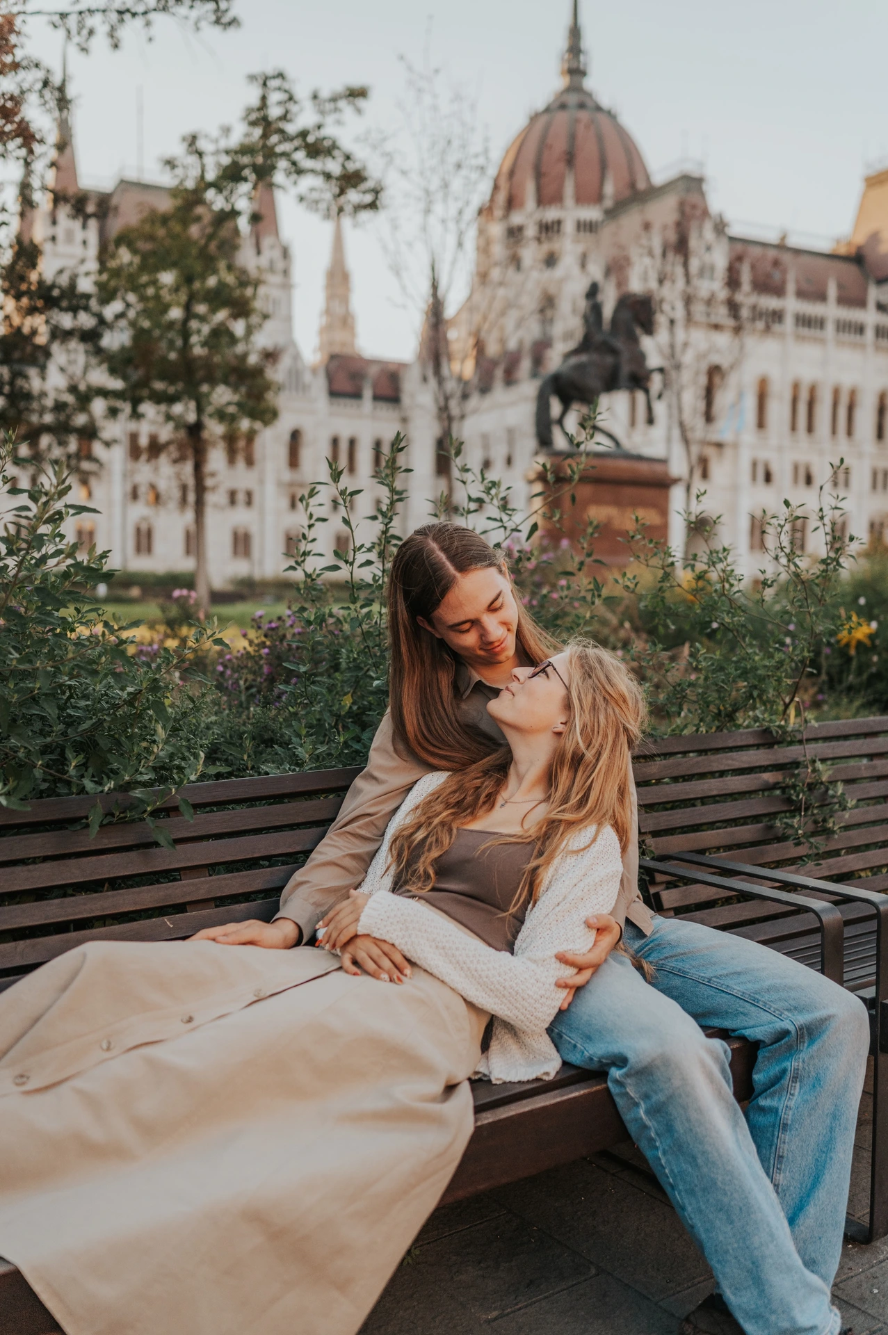 A closer portrait of the couple seated together on the bench during their Budapest photoshoot, with the flowing skirt in the foreground.