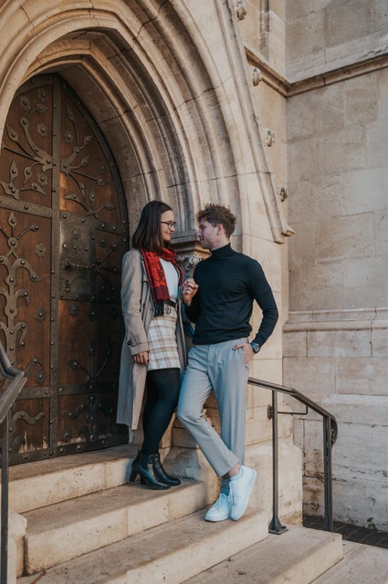 Budapest couple photoshoot: beside a carved door and iron handrail The couple standing together beside the carved wooden door and iron handrail at Matthias Church during a couple photoshoot in Budapest.