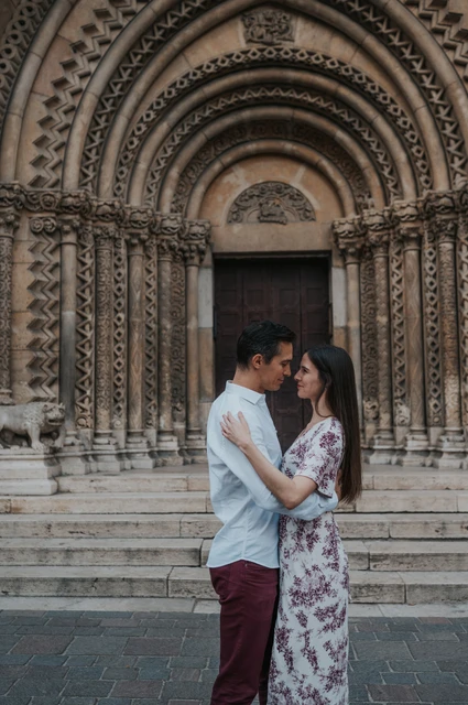 An embrace beneath the castle arches at a Budapest couple photoshoot The couple embracing in front of the carved stone doorway at Vajdahunyad Castle during their couple photoshoot in Budapest.