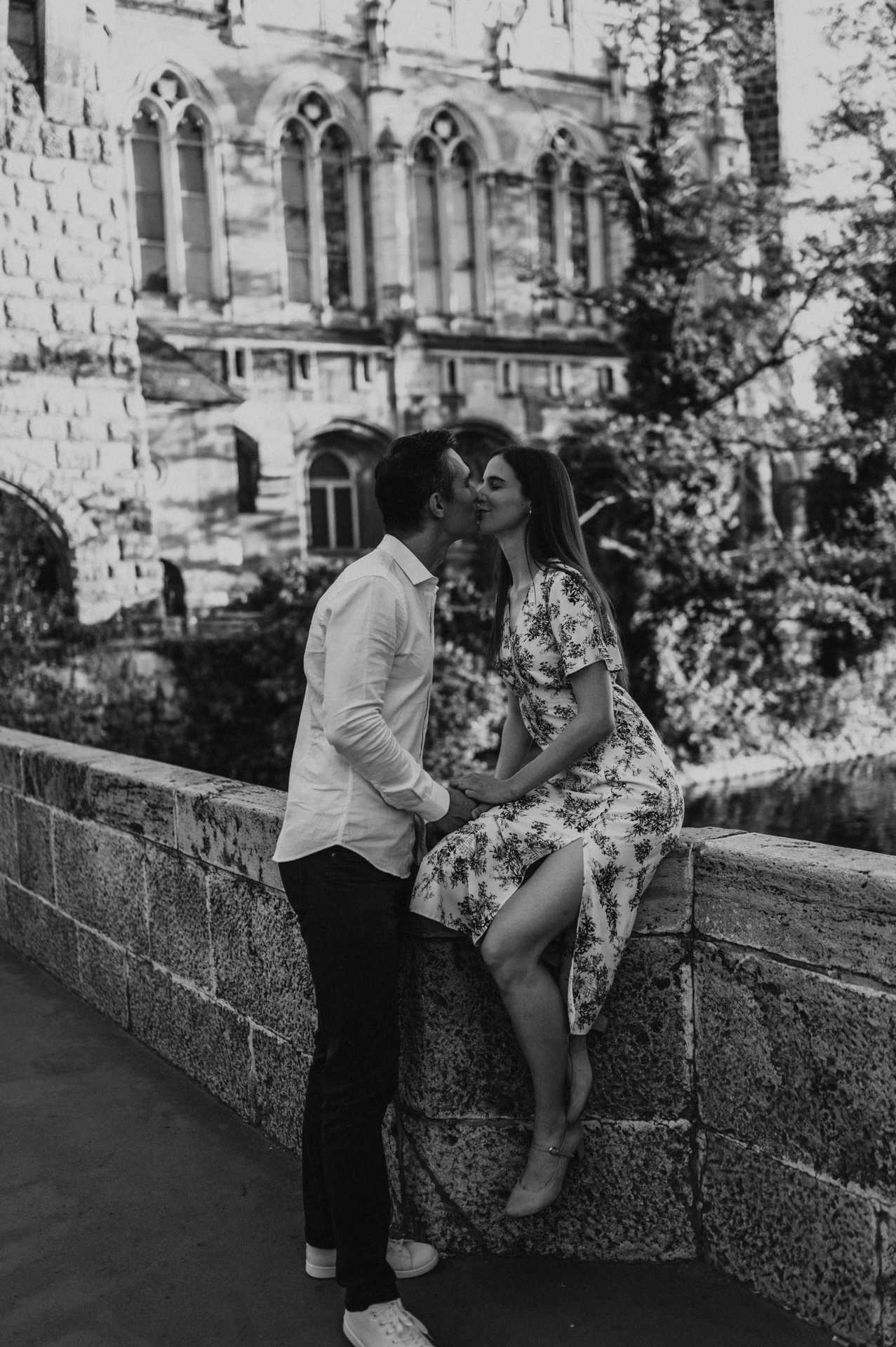 A closer black-and-white portrait of the couple embracing beside the stone wall at Vajdahunyad Castle during their couple photoshoot in Budapest.