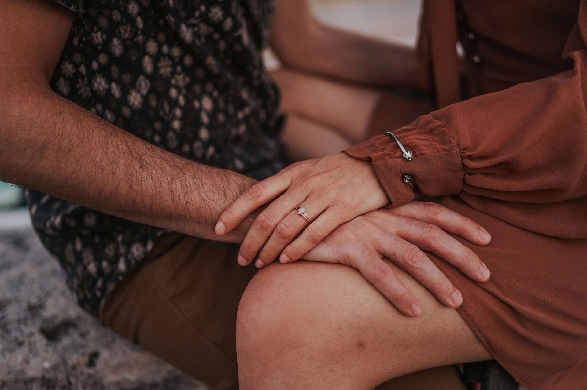 Budapest engagement photoshoot: Their hands and ring resting together A landscape close-up of the couple’s hands resting together on a lap, with the engagement ring clearly visible during their Budapest engagement photoshoot.