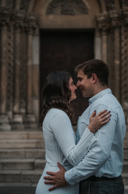 A close portrait by the castle doorway at a Budapest anniversary photoshoot A close portrait of the couple leaning towards one another with Vajdahunyad Castle’s doorway softly blurred behind them during their anniversary photoshoot in Budapest.