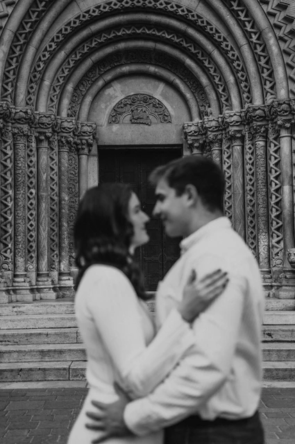 A soft castle portrait in black and white at a Budapest anniversary photoshoot A softly focused black-and-white portrait of the couple leaning close in front of Vajdahunyad Castle’s carved doorway during their anniversary photoshoot in Budapest.