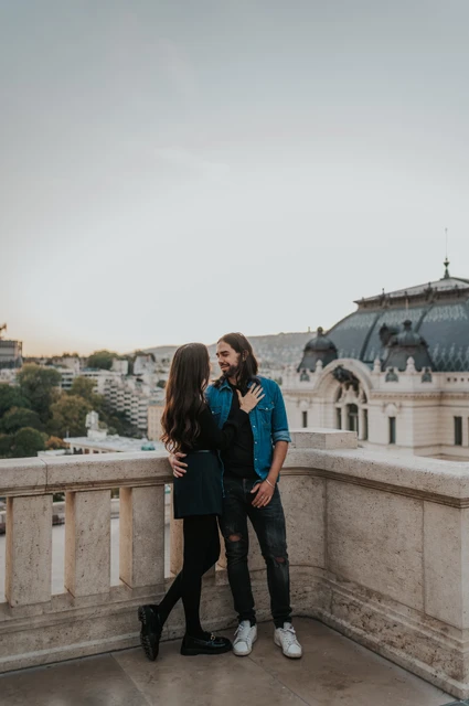 An embrace on the castle terrace at a Budapest couple photoshoot A full-length portrait of the couple embracing beside the corner of a stone terrace at Buda Castle during their couple photoshoot in Budapest.