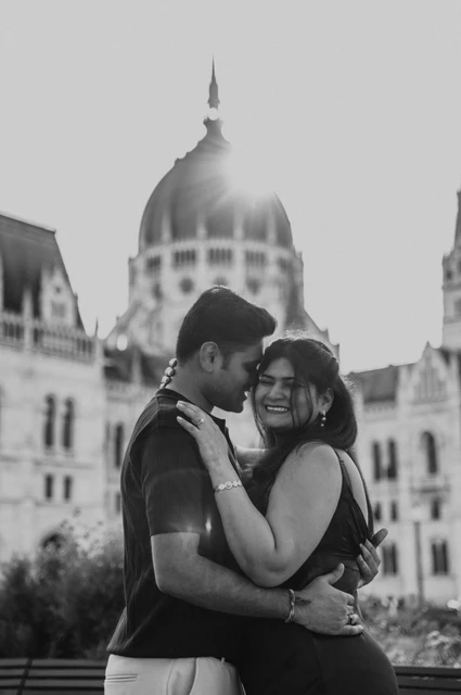 Budapest couple photoshoot smiles beneath the dome in black and white Black-and-white close portrait of the couple smiling beneath Parliament’s dome during their couple photoshoot in Budapest.