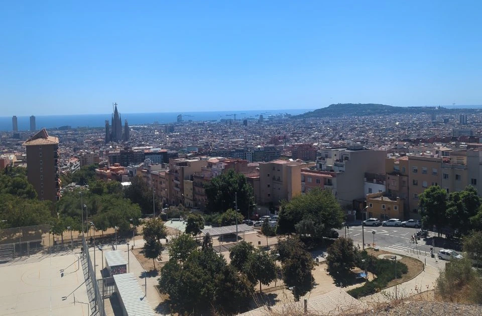 Barcelona Proposal Spots - Bunkers Approach View Barcelona stretches from Sagrada Família to the Mediterranean below a lower viewpoint on the Bunkers del Carmel approach, illustrating this proposal-setting route.