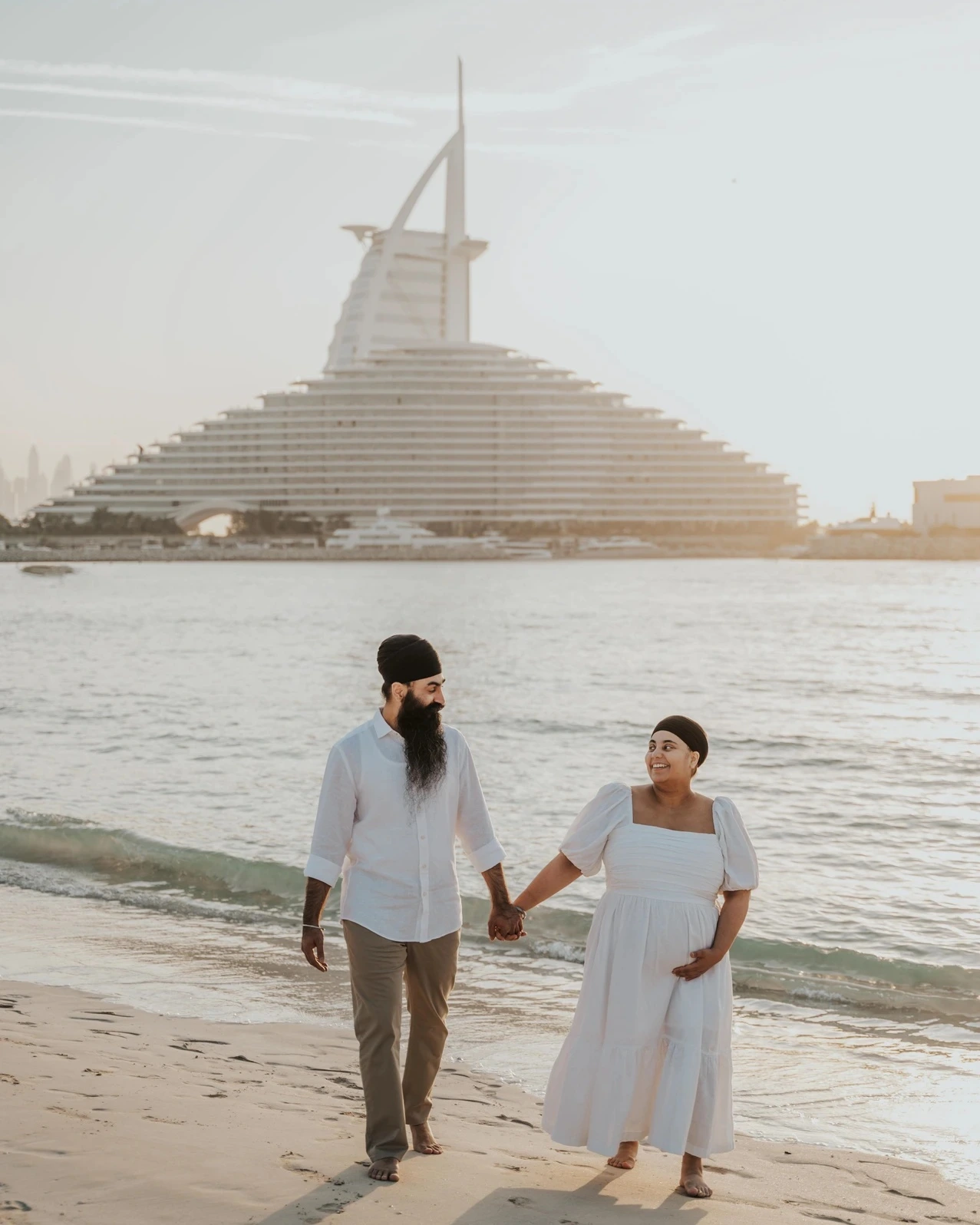 Expecting couple during a beach portrait, for the Maternity Photoshoot With the Burj Al Arab guide.