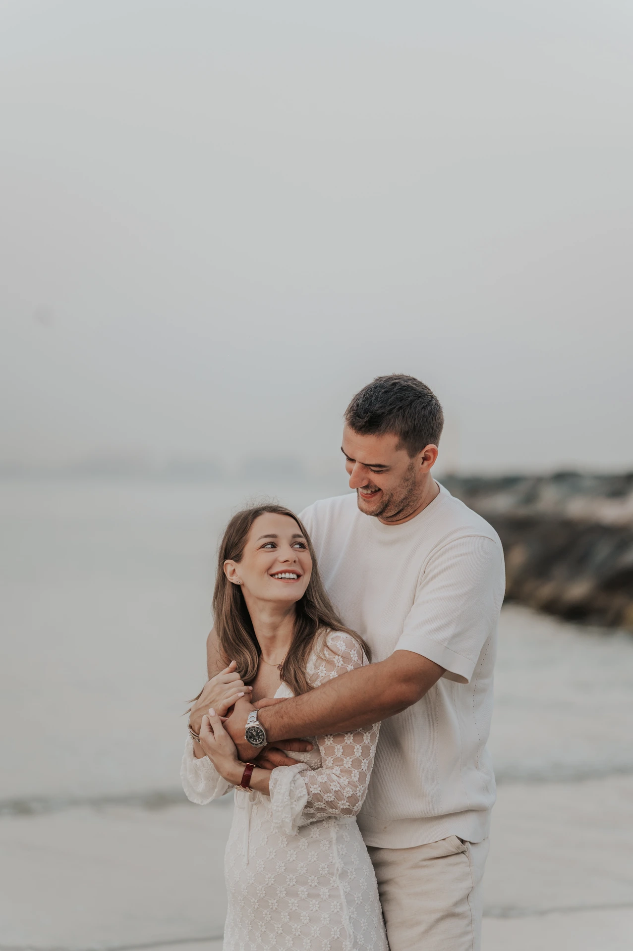 A close-up of an expecting couple smiling together on Dubai beach during a maternity photoshoot with soft seaside light.