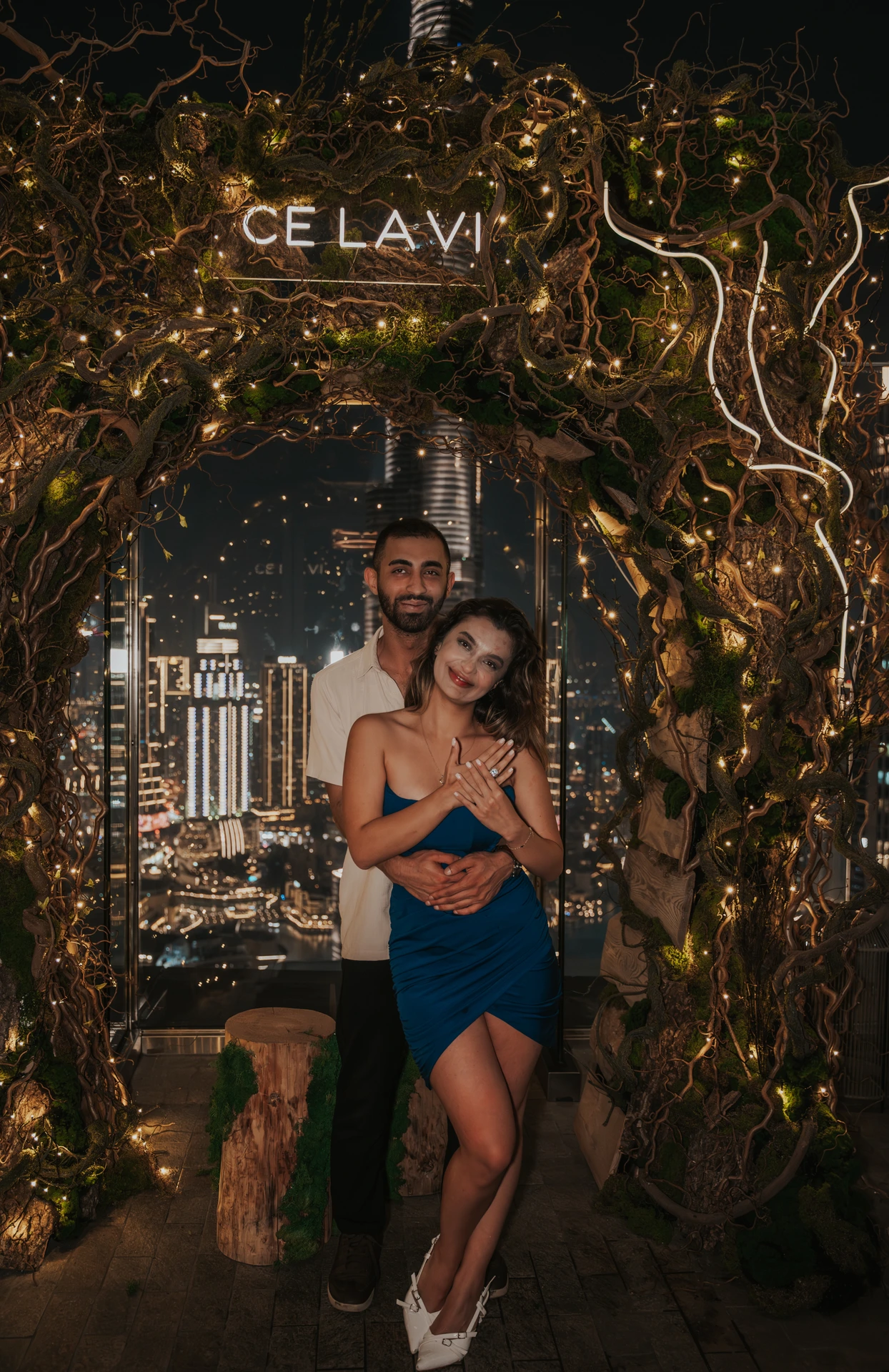 CE LA VI rooftop proposal Dubai - Couple Portrait A couple poses under the CE LA VI sign on a Dubai rooftop after their nighttime proposal, with city lights behind them.