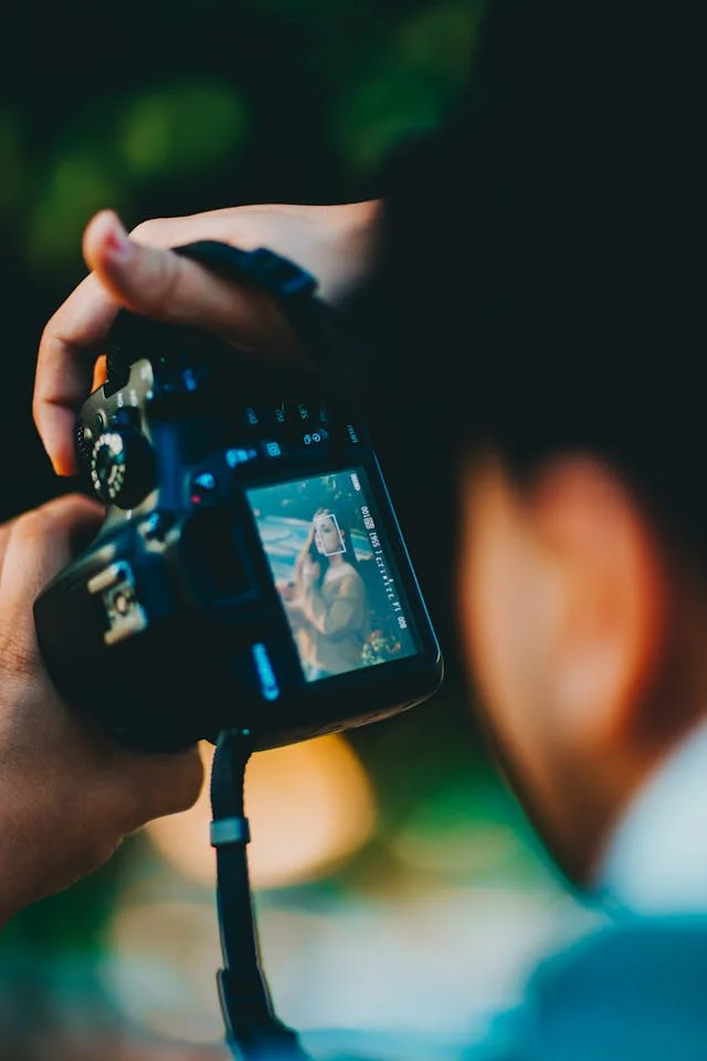 Photo of photographer with his viewfinder as subject with a woman in view