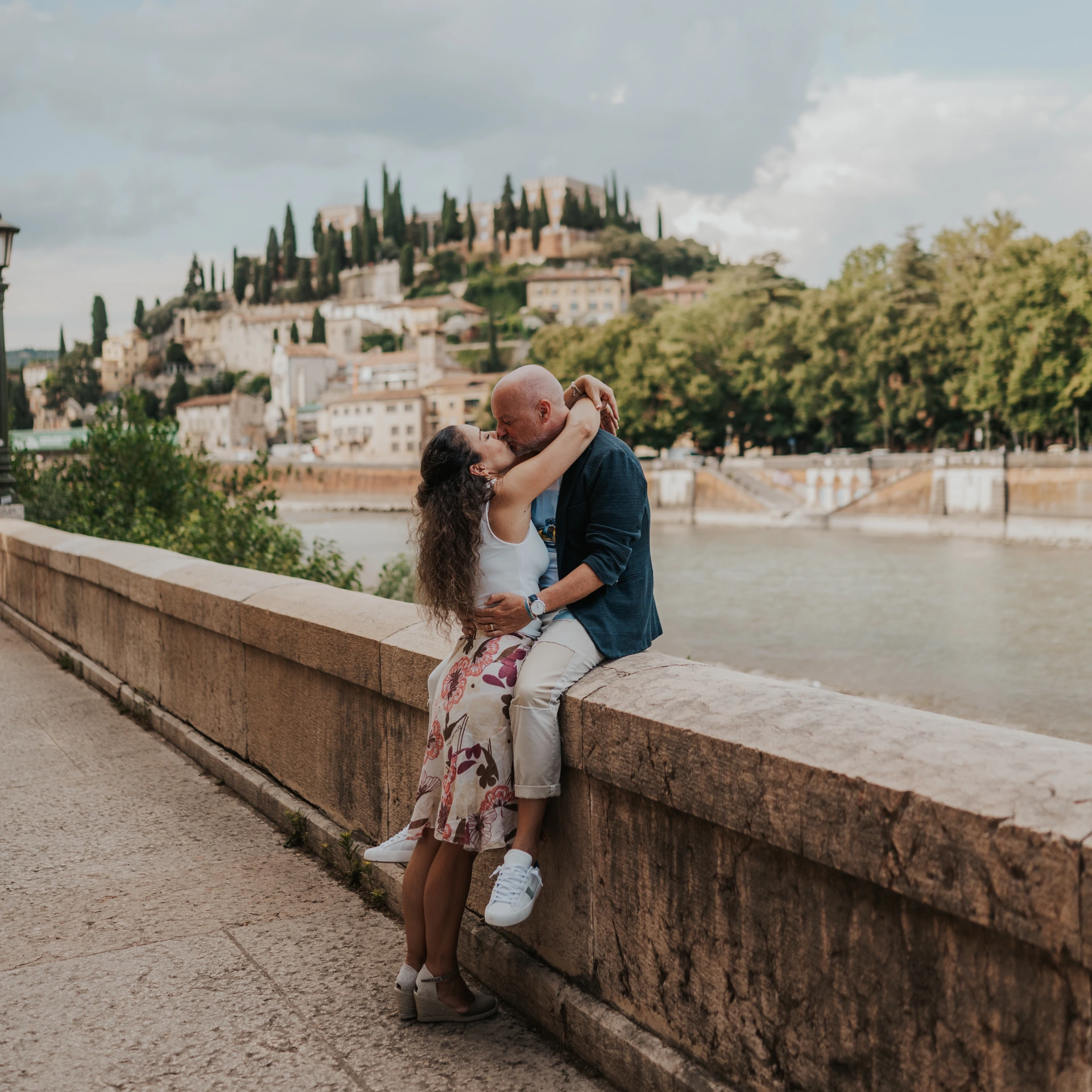 Couple beside the Adige with Castel San Pietro in the background