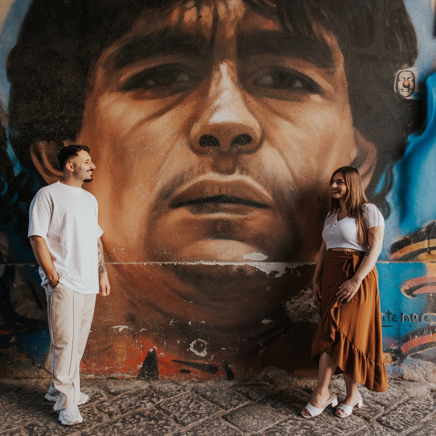 Couple in front of a Maradona mural on Vico dei Maiorani in Naples