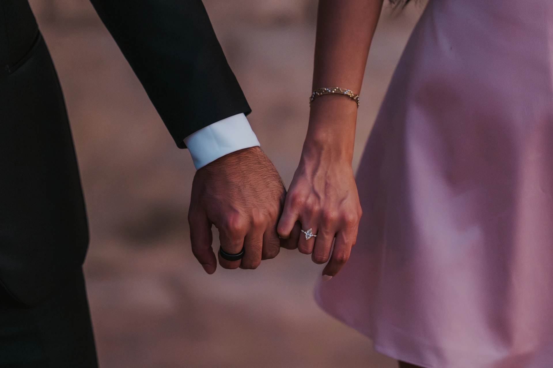 Close-up of a couple holding hands with an engagement ring visible during a romantic Dubai couple session.