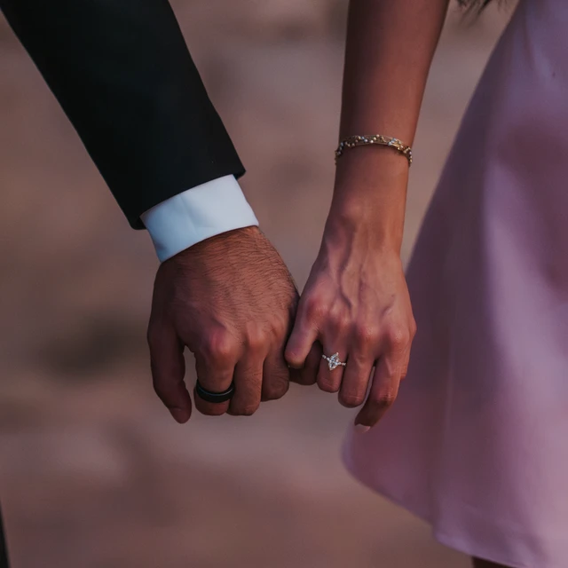 Couple photoshoot ideas Dubai - Ring detail close-up Close-up of a couple holding hands with an engagement ring visible during a romantic Dubai couple session.