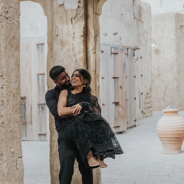 A couple in evening outfits shares a romantic moment in an Old Dubai heritage-style alley.