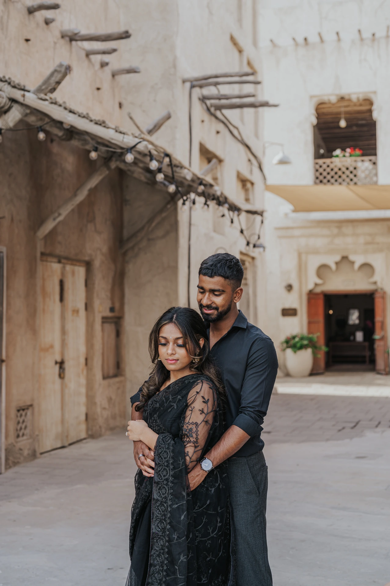 A couple walks through historic Old Dubai architecture during a lifestyle couple photoshoot.