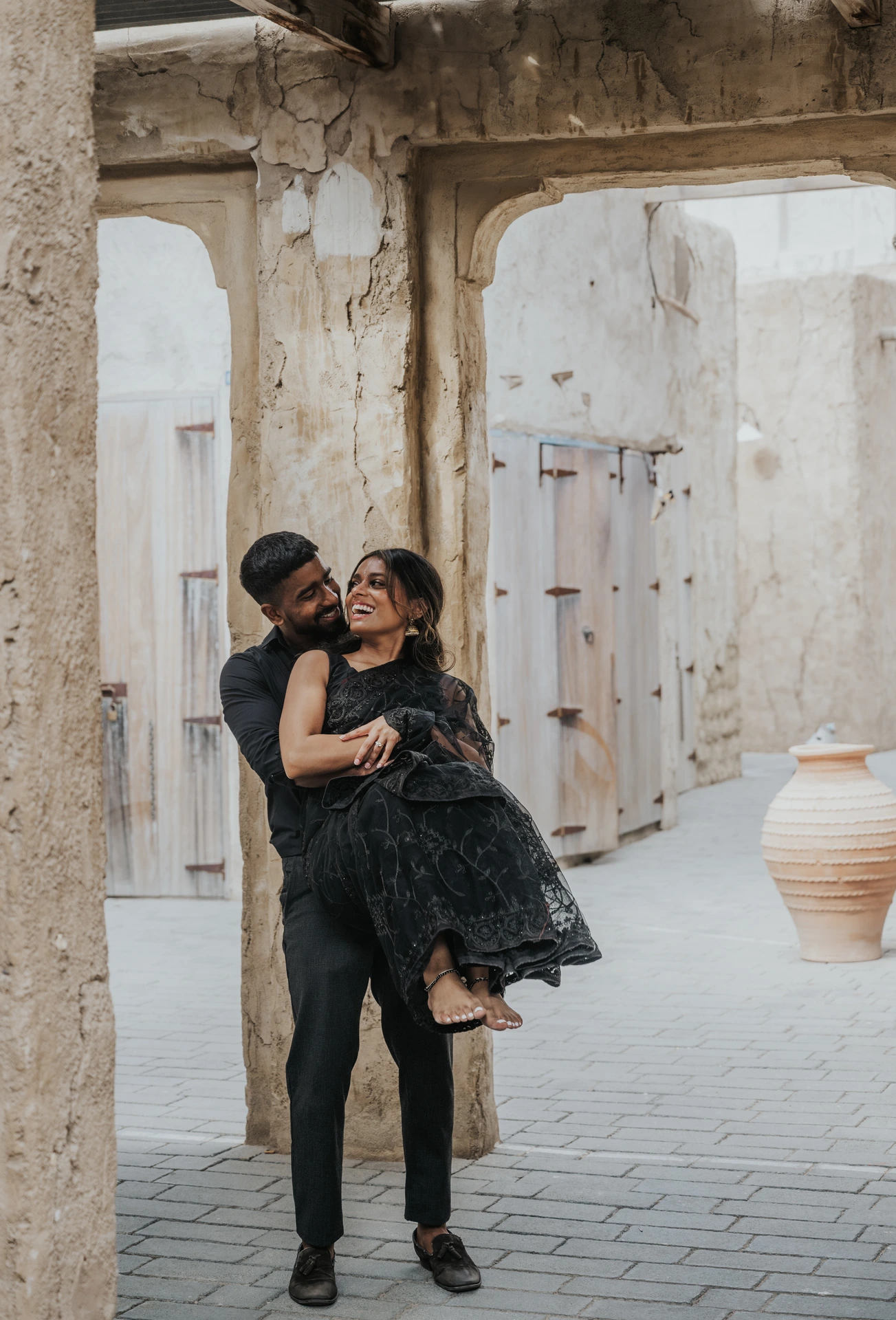 A couple embraces in a heritage-style Old Dubai alleyway during a romantic couple photoshoot.