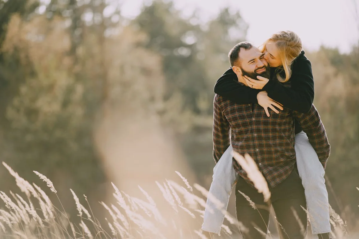 Couple in grain field laughing at eachother