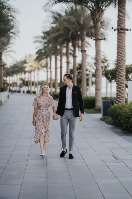 Couple walking in Creek Harbour Dubai palm-lined promenade