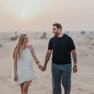 Couple walking on a dune after proposal in the Dubai desert