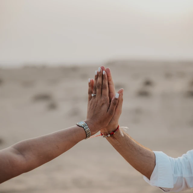 Dubai desert proposal Hand with diamond ring during Dubai desert proposal against the setting sun
